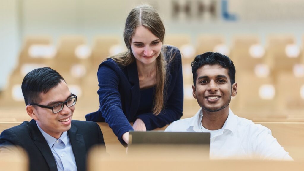 Three international mba students in a lecture hall at HHL.