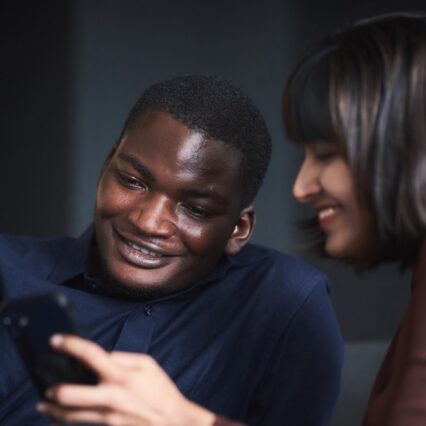 zwei Mba-Studenten an der hhl schauen auf ein Smartphone