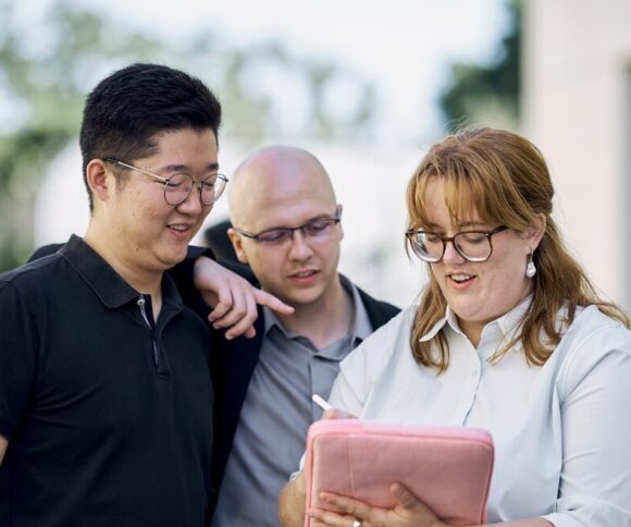 Mba Student Group looking at a Laptop.