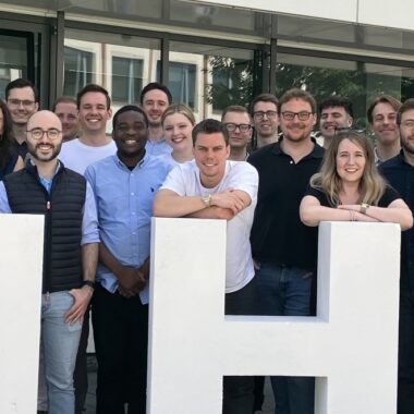 Eine große Gruppe von Promotionsstudierenden der HHL aus der ganzen Welt, alle lächeln.