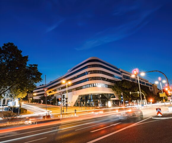 Nachtansicht eines modernen Gebäudes mit Lichtspuren in Stuttgart, Deutschland